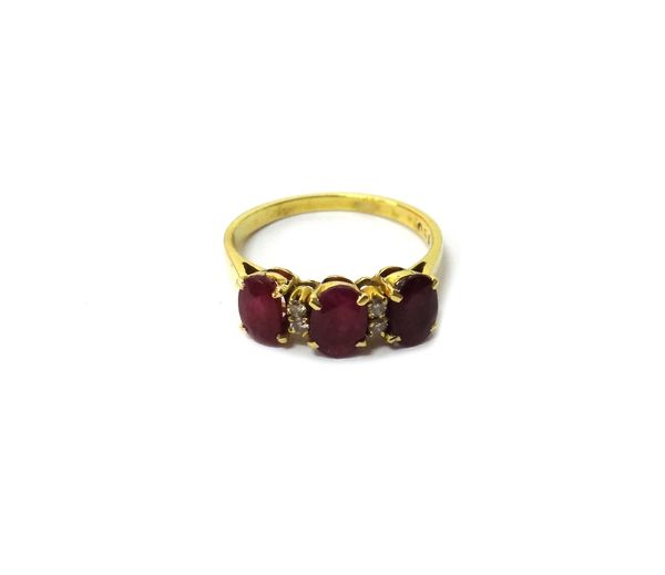 A gold, ruby and diamond set ring, claw set with three oval cut rubies and with two pairs of small circular cut diamonds, mounted at intervals, detail