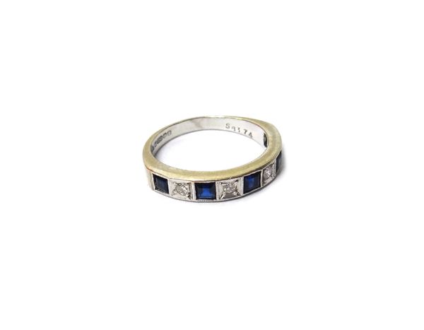 An 18ct white gold, sapphire and diamond set nine stone half hoop ring, mounted with five square cut sapphires alternating with four circular cut diam