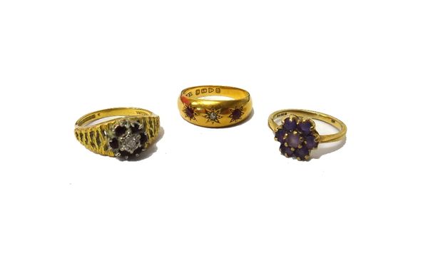 An 18ct gold, ruby and diamond set three stone gypsy ring, Chester 1916, a 9ct gold and amethyst set seven stone cluster ring and an 18ct gold, ruby a