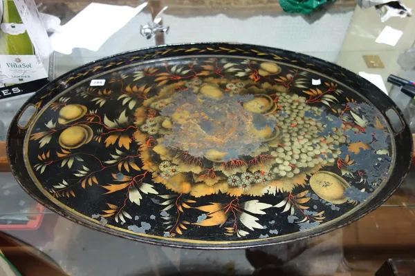 A black tole painted oval tray, 19th century, painted with fruit. (a.f), 75.5cm wide.