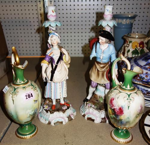 Two Royal Worcester ewers (a.f) and two figural Continental candlesticks (a.f). (4)