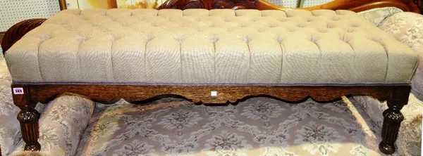A 20th century oval footstool with grey button upholstery.
