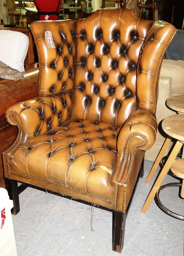 A 20th century brown leather button upholstered wing chair.