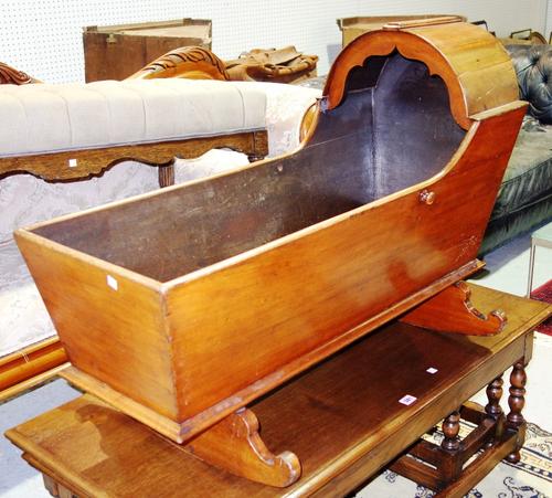 A 19th century mahogany rocking crib with serpentine base.