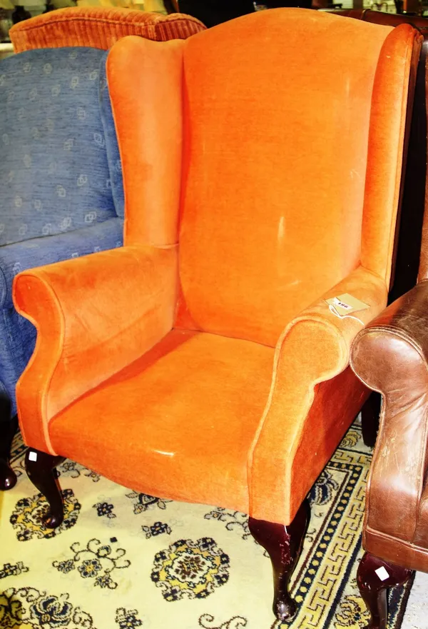 A 20th century orange upholstered wing armchair.