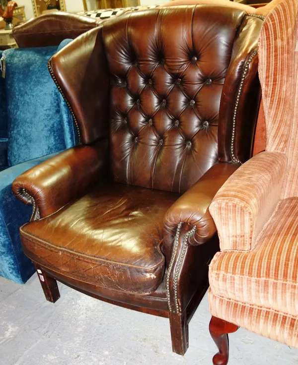 A 20th century brown leather upholstered wing armchair.