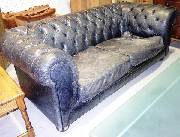 A blue leather button upholstered Chesterfield style sofa.