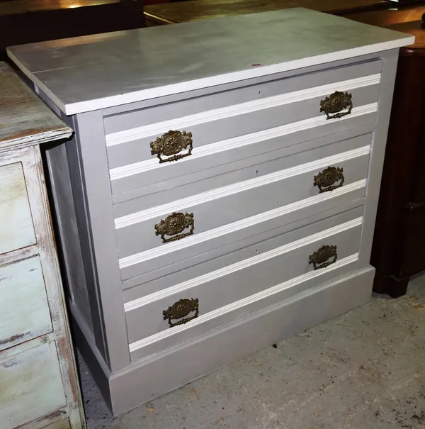 A grey and white painted three drawer chest.