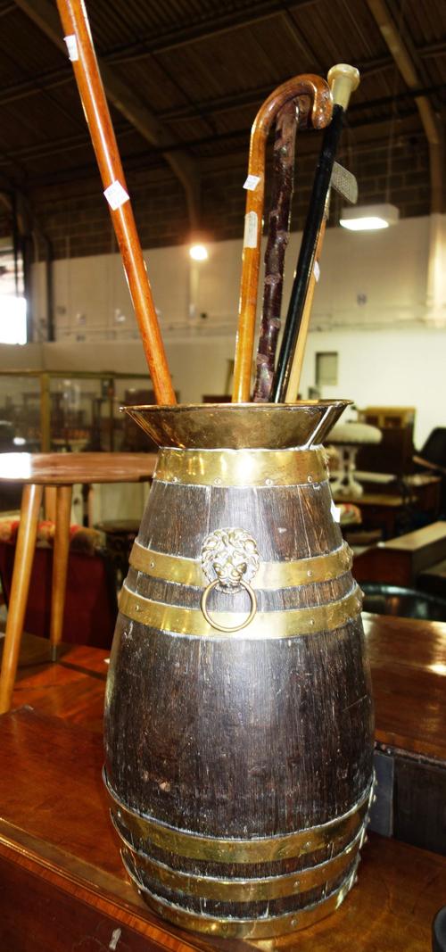 An oak coopered stickstand and a quantity of walking sticks.