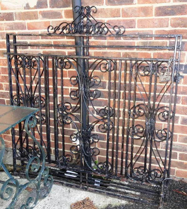 A pair of early 20th century black painted wrought iron entrance gates, each gate 131cm wide. (2)