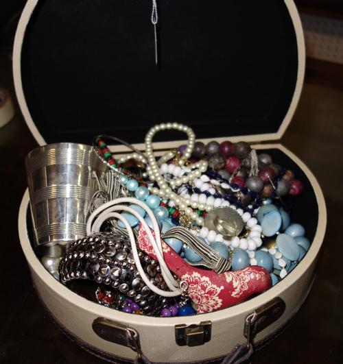 A quantity of costume jewellery and a silver plated beaker. (qty)