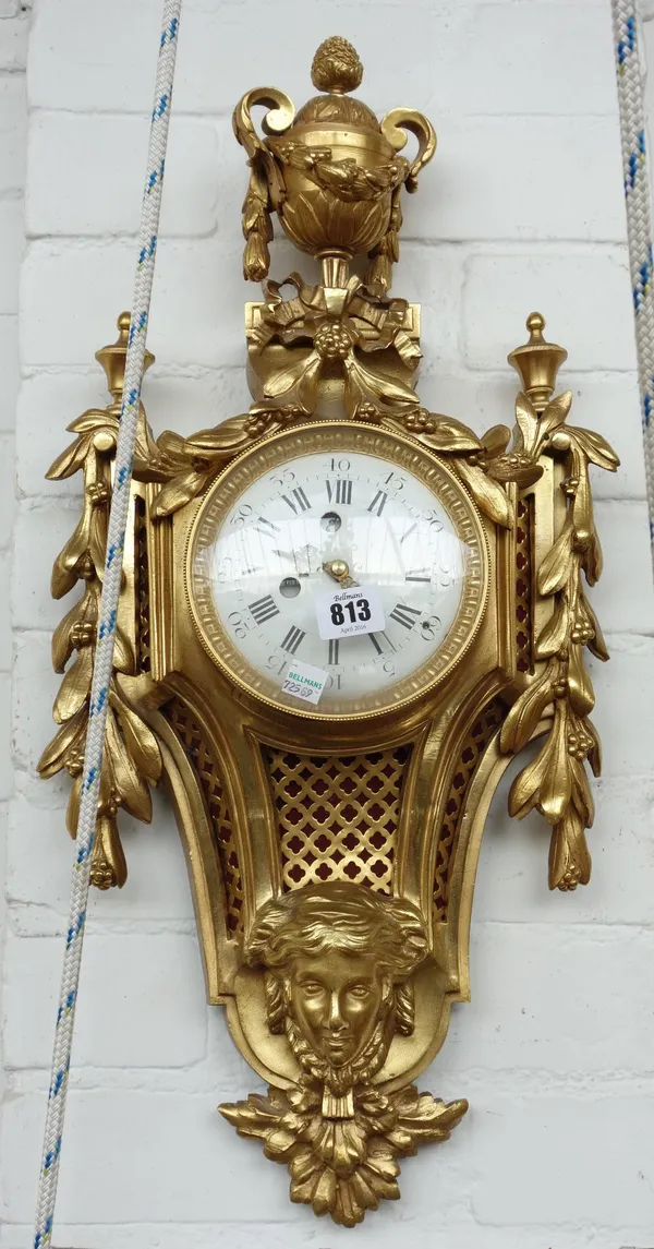 A gilt bronze Cartel clock, early 20th century, with urn finial over a white enamel dial flanked by foliate swags, with pierced grille and mask embell