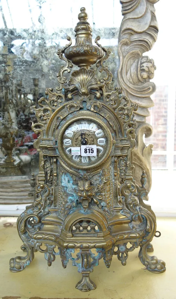 A brass clock garniture, late 20th century, with two handled urn surmount over a pierced foliate cast body flanked by a pair of six light candelabra,