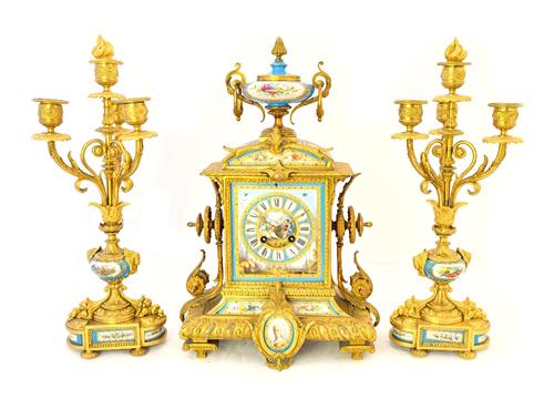 An ormolu and porcelain inset mantel clock garniture, late 19th century, with urn surmount and porcelain dial plate flanked by four branch candelabra