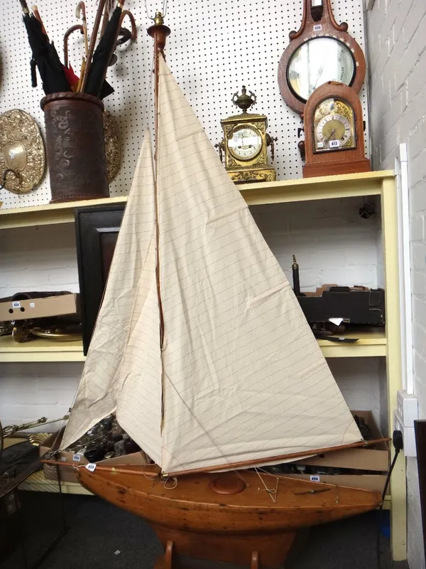 A wooden model sailing boat, mid 20th century, with cotton sails on a later oak stand, 180cm high.