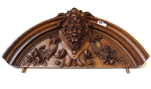 A pair of Continental walnut pediments, early 20th, century, each carved with fawn masks and and flanked by cornucopias of flowers within a domed step
