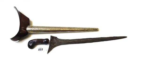 A Sumatran Kris, 19th century, with watered steel blade and a carved wooden handle, in a wooden and brass bound sheath.