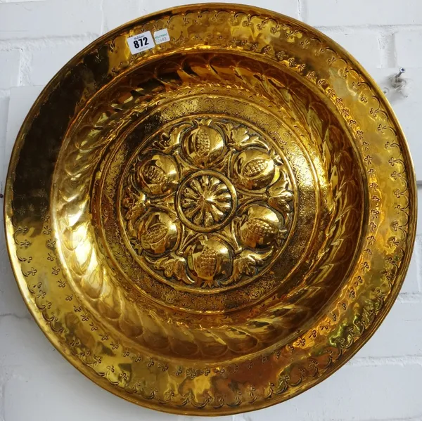 A Nuremberg brass alms dish, 16th century, with raised stylised flowerheads within a wide foliate border, 48.5cm diameter.