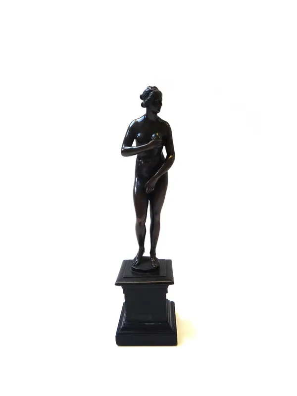 An Italian bronze figure of the Venus de Medici, late 18th century/early 19th century, with shaped base and an ebonised wooden plinth, 19cm high exclu
