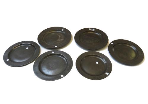 A pair of English pewter broad rimmed chargers, late 17th century, (34cm dia), and four smaller, all with armorial crest and touch marks to rear. (6)