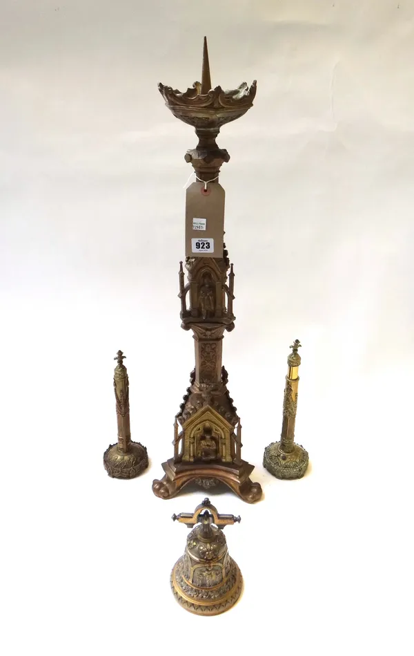 A Victorian brass altar stick of Gothic form (70cm high), two Victorian brass table screens/fans and a brass inkwell of bell shape relief cast with re