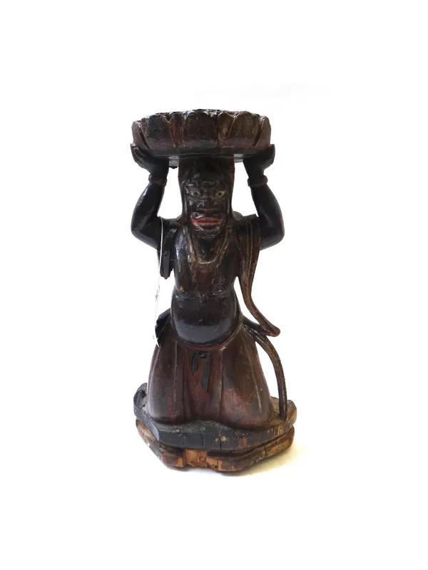 A South East Asian polychrome painted carved wooden figure, late 19th century, depicting a Chinese temple god holding a lotus leaf above his head (a.f