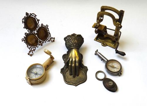 A small brass three division photograph frame with foliate decoration, 10cm high, a faux ivory compass, another compass, a Victorian brass paper clip