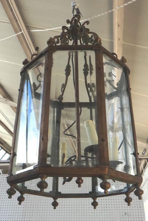 A pair of octagonal brass hall lanterns, mid 20th century, each with scrolled suspension ribs and internal four light lighting, 92cm high. (2)