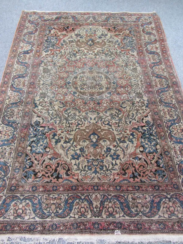 A Tehran rug, Persian, the beige field with a bold madder roundel, arabesque spandrels, all with floral vines, a complementary beige border of indigo