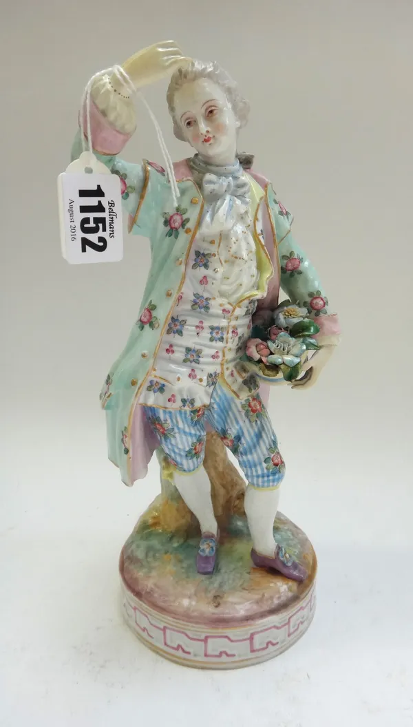 A German porcelain figure modelled as a dandy holding a basket of flowers, standing on a circular base, with painted marks, 26.5cm high, together with