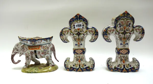 A French faience 'elephant' vase, early 20th century, 15cm high, and a pair of faience 'fleur de lys' shaped vase garnitures, 25cm high. (3)