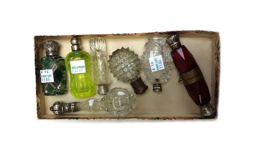 A Victorian ruby glass scent bottle, the facet cut body hinged in the centre and with silver foliate cast caps to either end, 11cm, together with a gr