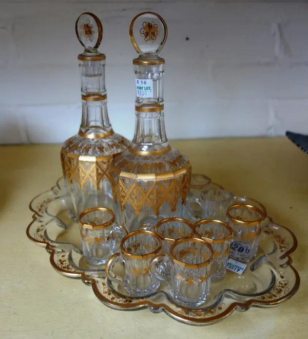 A pair of gilt glass decanters and stoppers, 19th century, of faceted form, together with a matching shaped tray and ten matched glasses, the tray 32.