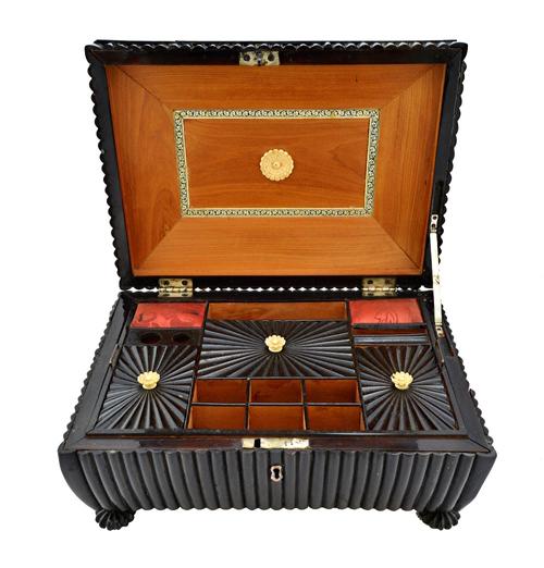 An early 19th century horn veneered sandalwood Anglo-Indian sewing box, of shallow sarcophagus form, with fitted interior and melon feet, 33cm wide.