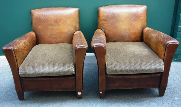 A pair of early 20th century French brown leather upholstered easy armchairs, on tapering square supports. (2)