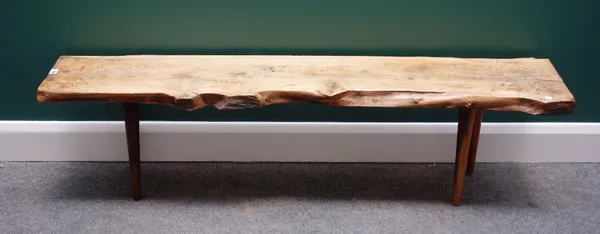 Reynolds of Ludlow; a 20th century naturalistic formed bench, the singe slab yew top on four staked supports, with maker's plaque to underside, 152cm