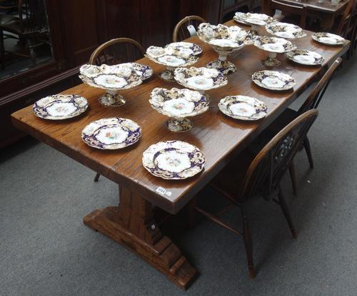 A 17th century style oak refectory table, the solid plank top on a pair of silhouette trestle end standards, united by a central stretcher, 210cm long