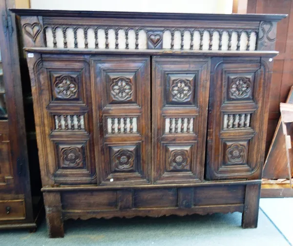 A 19th century French chestnut Breton lit-clos cabinet, with sliding doors and bobbin turned decoration, on block feet, 190cm wide x 179cm high.