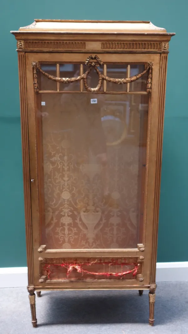 An early 20th century gilt framed display cabinet, the single glazed door with wreath and swag decoration, on turned fluted supports, 81cm wide x 176c