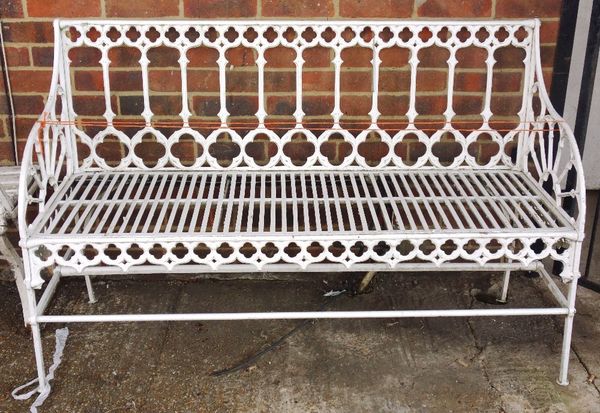 A white painted iron framed garden bench of Gothic Revival design, 145cm wide.