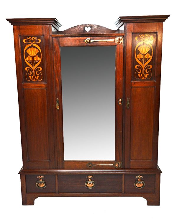 Shepland and Petter; an Art Nouveau marquetry inlaid sentry wardrobe, with bevelled mirrored central door and two drawer base, 274cm wide x 209cm high