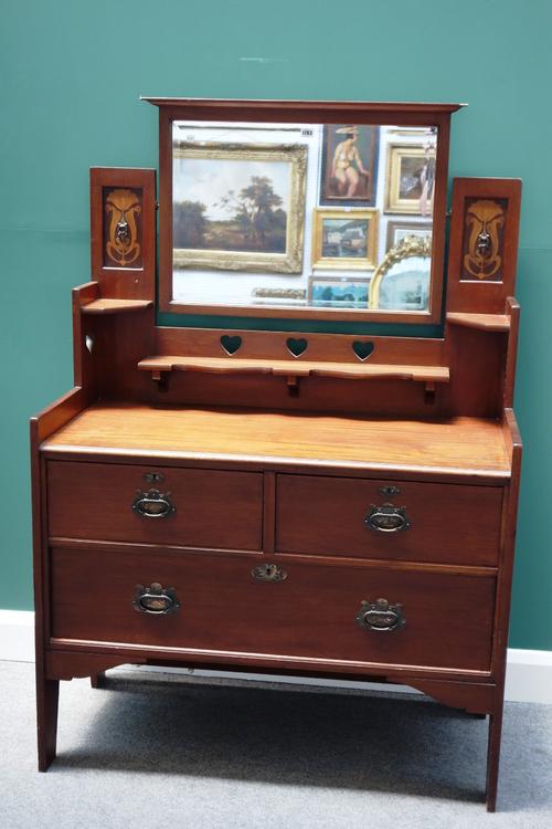 Shapland and Petter; an Art Nouveau inlaid mahogany dressing chest, with bevelled swing mirror over two short and one long drawer, 108cm wide.