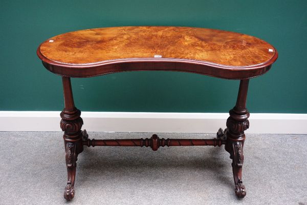 A Victorian figured walnut kidney shaped writing table, the pair of carved column supports united by a spiral fluted stretcher, 113cm wide.