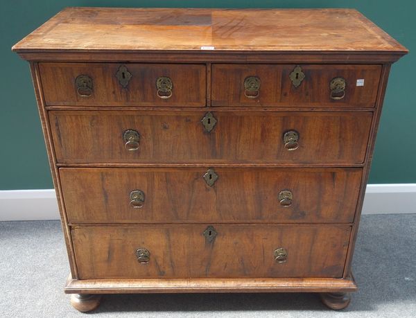 A William and Mary figured walnut chest of two short and three long graduated drawers, on bun feet, 98cm wide.     Item 23