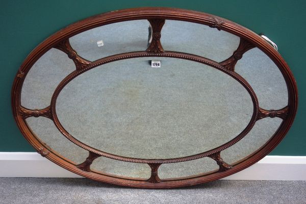 An 18th century style mahogany framed segmented oval wall mirror, with bevelled central plate, 100cm wide x 81cm high.