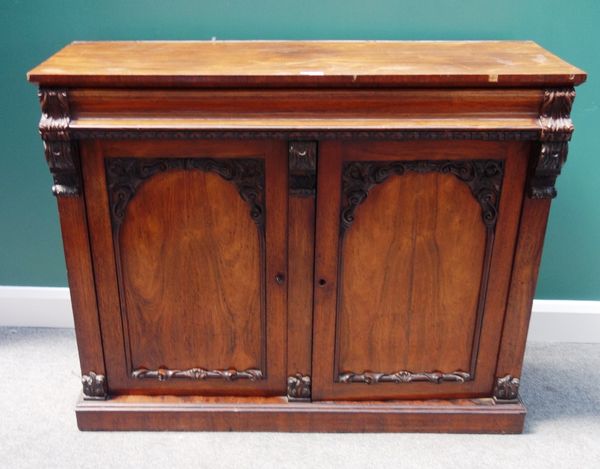 A William IV rosewood chiffonier, the carved back over cushion drawer and a pair of arch panel cupboards, on plinth base, 122cm wide.