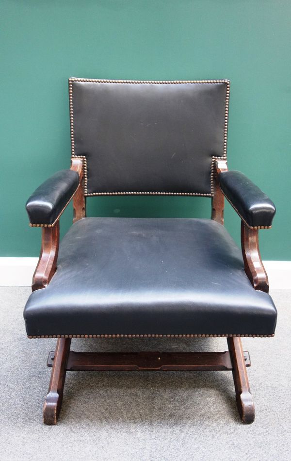 A Victorian oak Gothic Revival open armchair, on a chamfered 'X' frame base.