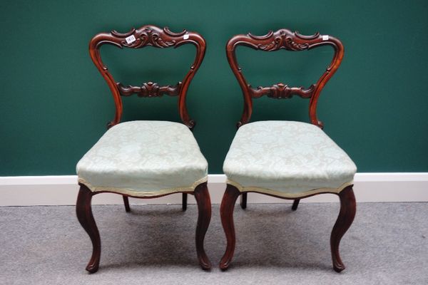 A set of six Victorian rosewood balloon back dining chairs, with carved and shaped back and serpentine seat, on cabriole supports, (6).