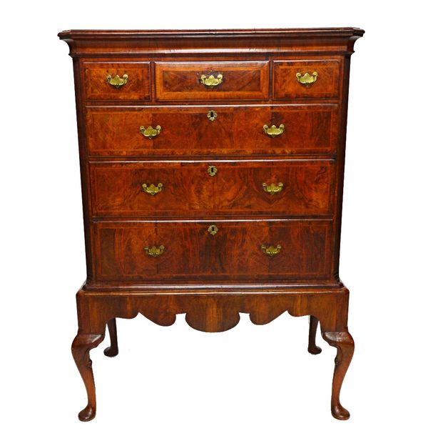 An early 18th century crossbanded figured walnut chest on stand, of three short over three long graduated drawers, flanked by fluted canted corners, t