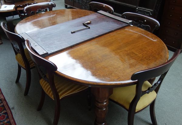 A Victorian mahogany extending dining table, the oval top on four turned supports, to include two extra leaves, 123cm wide x 142cm long x 162cm long e